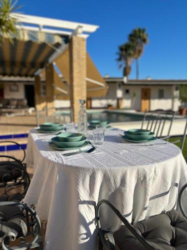 a table with a white table cloth and plates on it at El Patio de las Minas in Aznalcázar