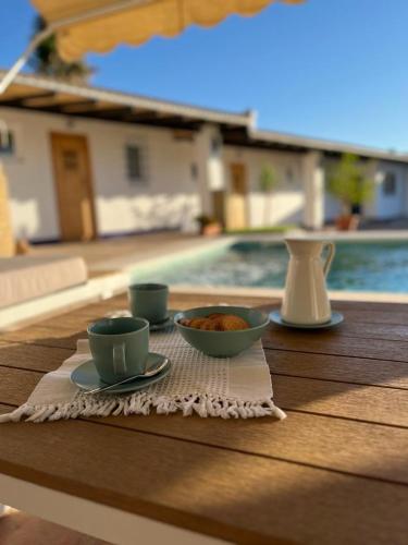 a table with two cups and a bowl of food at El Patio de las Minas in Aznalcázar