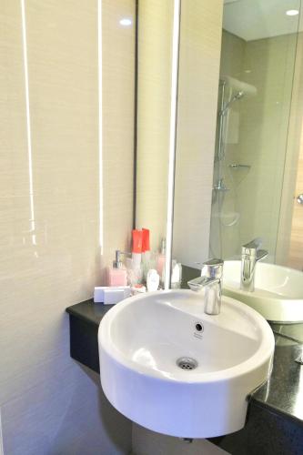 a bathroom with a white sink and a mirror at @Hom Semarang Simpang Lima in Semarang