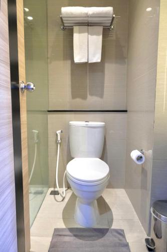 a bathroom with a white toilet in a room at @Hom Semarang Simpang Lima in Semarang