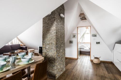 sala de estar con mesa y pared de ladrillo en Willa Art, en Zakopane
