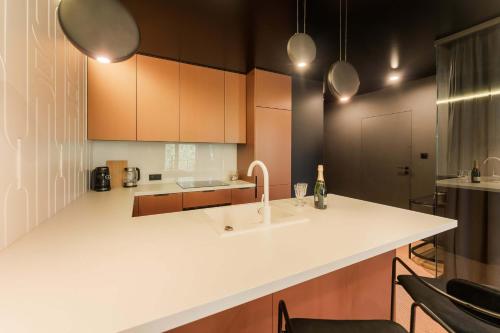 eine Küche mit Spüle und Theke mit Stühlen in der Unterkunft Salt Island Apartments in Kołobrzeg