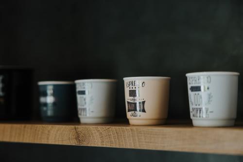 a row of coffee cups sitting on a shelf at Pearl Apartel in Volos