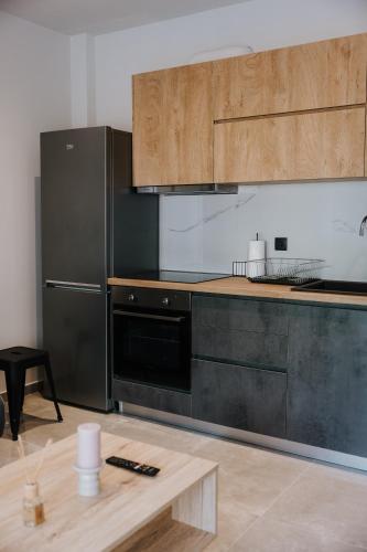 a kitchen with a black refrigerator and a table at Pearl Apartel in Volos