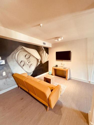 a living room with a large painting of a man on the wall at La Merveilleuse by Infiniti hôtel in Dinant