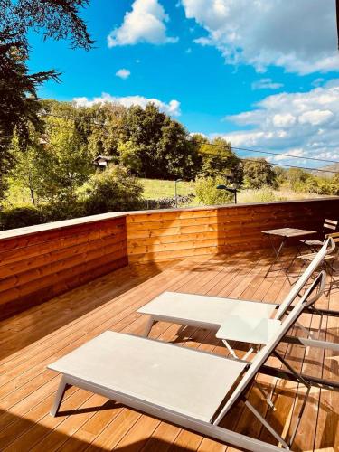 a deck with two chairs and a bench on it at La Merveilleuse by Infiniti hôtel in Dinant