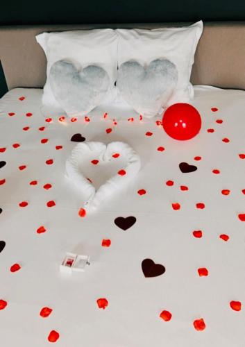 two hearts are laying on a bed with valentines hearts at La Merveilleuse by Infiniti hôtel in Dinant