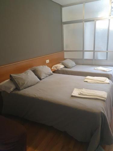 two beds in a room with a window at A Concha in Lavacolla
