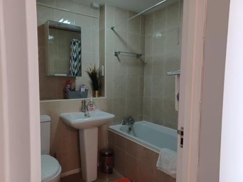 a bathroom with a sink and a tub and a toilet at Huku Kwetu -The Maltings White Door-1st Floor-2 Bedroom Apartment -Self Catering-Quiet- Free Parking in Dunstable
