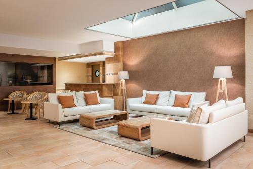 una sala de estar con 2 sofás blancos y una mesa. en Sunotel Central, en Barcelona