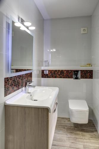 a white bathroom with a sink and a toilet at Hotel Duchess in Varna City