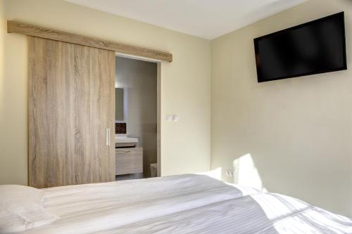 a bedroom with a bed and a television on the wall at Hotel Duchess in Varna City