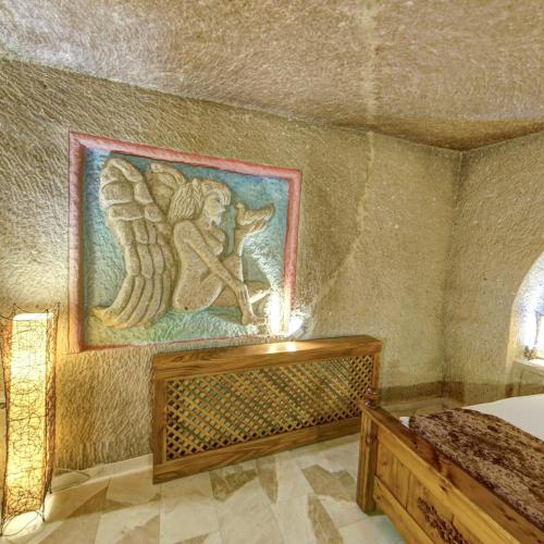 a painting on the wall of a room with a bed at Roma Cave Suite in Goreme