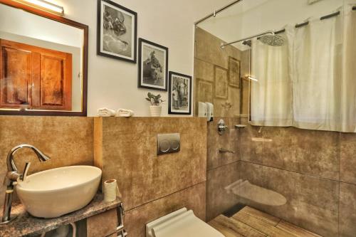 a bathroom with a sink and a shower and a toilet at Vala House in Cherai Beach