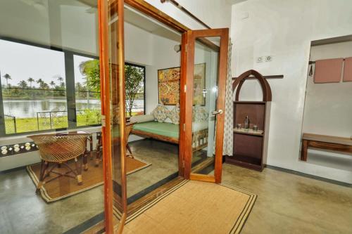 a living room with a door open to a room with a table at Vala House in Cherai Beach