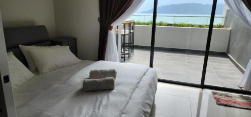 コタキナバルにあるThe Shore Ns Studio Suites Sea Viewのバルコニー付きの客室の白いベッド1台分です。