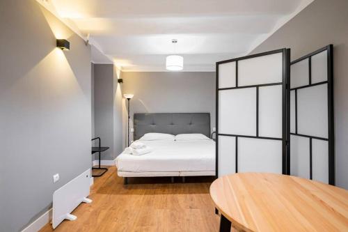 a bedroom with a white bed and a wooden table at Chamberi - Quiet flat, ideal for families CAS in Madrid