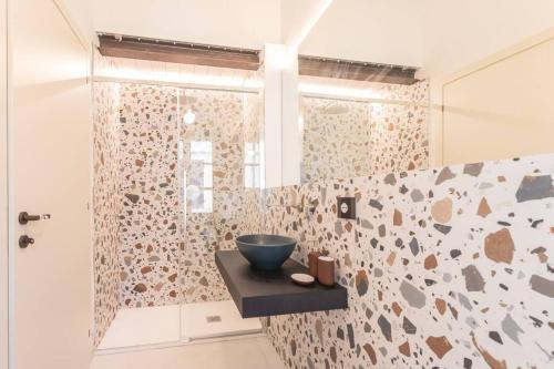 La salle de bains est pourvue d'une douche avec un bol sur un comptoir. dans l'établissement Luxury & Design: Oasi nel centro storico di Rimini, à Rimini