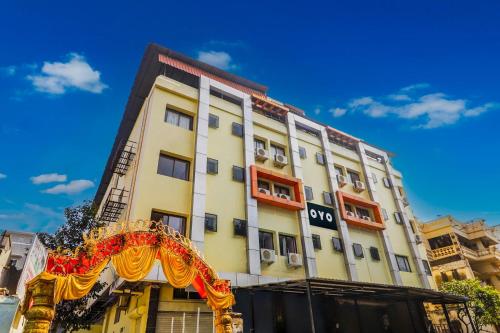 a tall yellow building with a red and yellow arch at Super OYO 77115 Flagship Hotel Vaishnavi Palace in Hyderabad