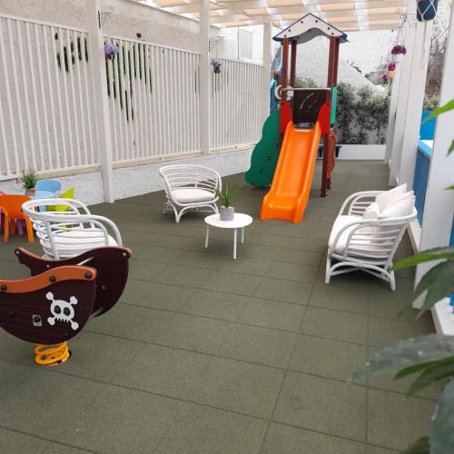 a patio with a playground with chairs and a swing at Mediterrâneo Madeira in São Vicente