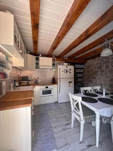 a kitchen with white appliances and a table with chairs at Villa Tomitorija in Kaprije