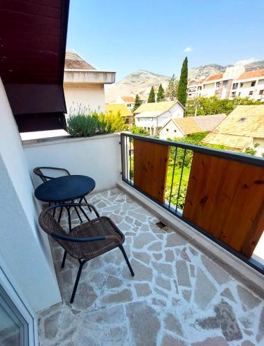 a balcony with two chairs and a table and a fence at Herceg Vila in Trebinje