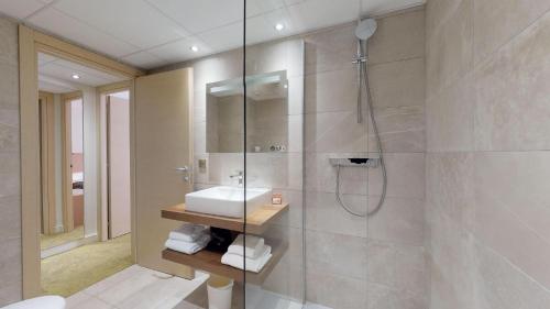 La salle de bains est pourvue d'un lavabo et d'une douche. dans l'établissement Hôtel Le Rocher, à Calvi