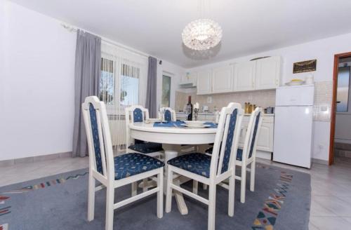 cocina con mesa blanca y sillas en Apartments Toma, en Kaštela