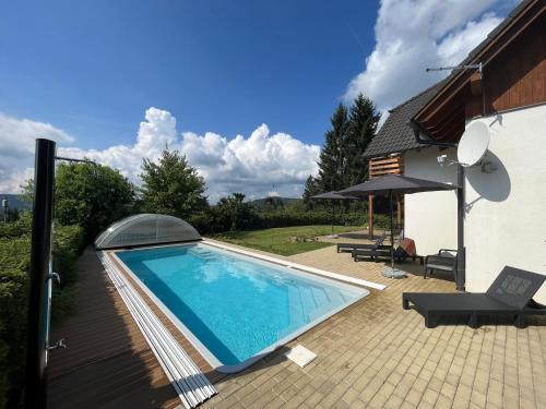 a swimming pool next to a house at Villa Gamma - Lipno Home in Lipno nad Vltavou