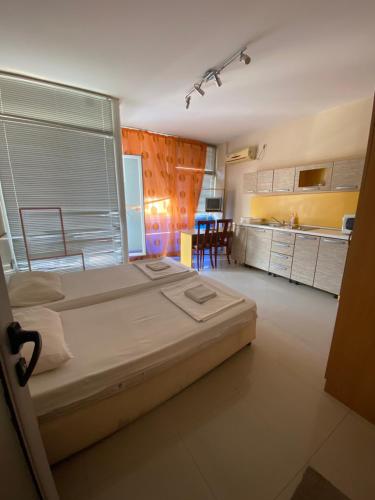 Un dormitorio con una cama grande y una cocina. en Studios & Apartments Perla, en Sunny Beach