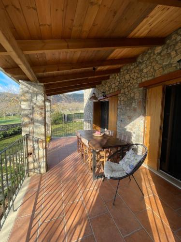 a patio with a table and chairs on a deck at Country Stone House ,next to Kalavrita in Kalavrita