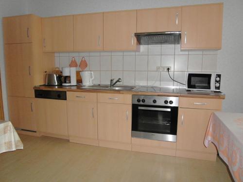 a kitchen with wooden cabinets and a stove top oven at Two separate farmhouse apartments under one roof in Trendelburg