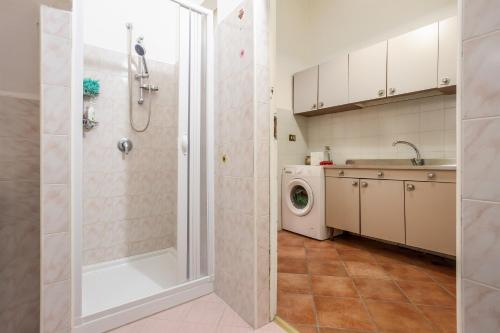 y baño con ducha y lavadora. en Casa A Cinisi Vicino Al Centro, en Cinisi