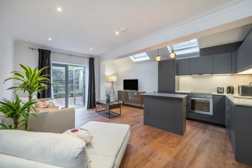 ein Wohnzimmer mit einem weißen Sofa und einer Küche in der Unterkunft Spacious Apartments London Eye, Westminster, Big Ben, Borough Market in London