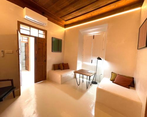 een woonkamer met 2 bedden en een tafel bij uma casa em entradas guesthouse in Entradas