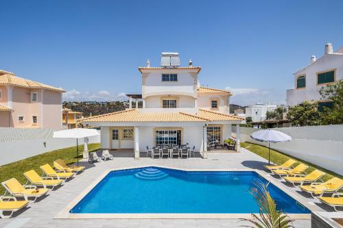 a villa with a swimming pool in front of a house at Casa Vela by OCvillas in Albufeira