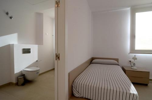 sypialnia z łóżkiem, toaletą i oknem w obiekcie VILLA PINELL w mieście Torroella de Montgrí