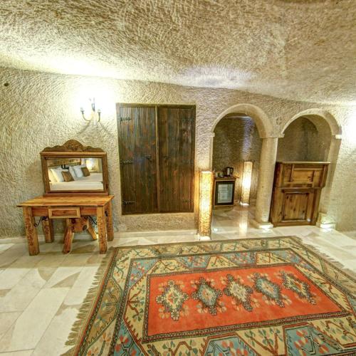 a room with a rug and a table and a mirror at Roma Cave Suite in Goreme