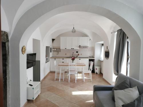 sala de estar y cocina con mesa y sillas en appartamento in Borgo storico., en Pontremoli