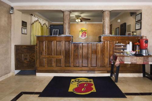 a dining room with a wooden wall and a rug at Super 8 by Wyndham Childress in Childress