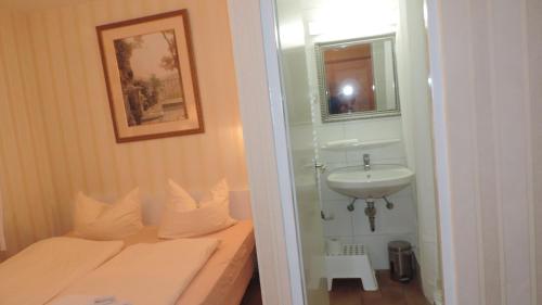 een kleine badkamer met een bed en een wastafel bij Haus Sonneneck 2 in Dierhagen