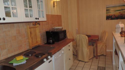 eine Küche mit einem Herd und einer Mikrowelle in der Unterkunft Haus Sonneneck 2 in Dierhagen