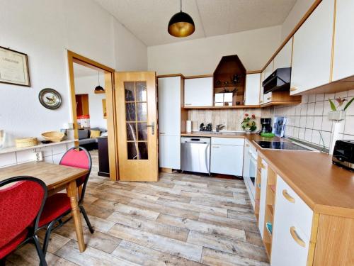 cocina con armarios blancos y mesa de madera en 2-Zimmer-Apartment für 4 PersonenFeWo 1, 