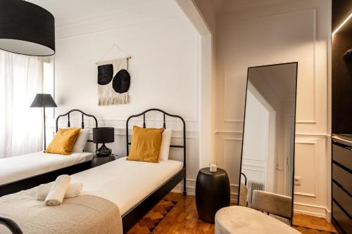 - une chambre avec 2 lits et un miroir dans l'établissement Akicity Benfica Serene, à Lisbonne