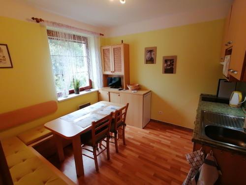 uma cozinha com mesa e cadeiras num quarto em Apartmán Na Horách em Destné v Orlických horách