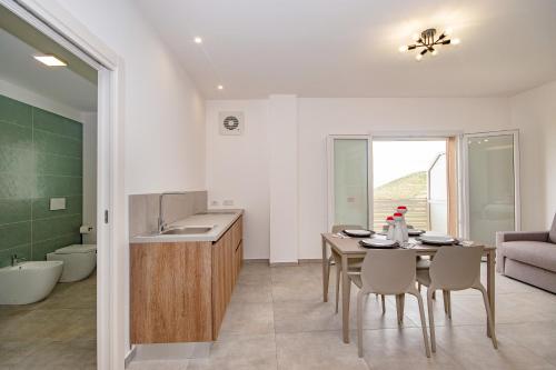 een keuken en eetkamer met een tafel en stoelen bij Coste Ponente Appartamenti Turistici in Ragusa