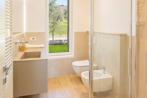 bagno con servizi igienici, lavandino e finestra di Casa Palai luxury home a Bardolino