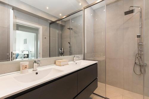 W łazience znajduje się biała umywalka i prysznic. w obiekcie Secluded Elegance at Villa Giem - 4 Bedrooms - Unmatched Sea Views - Private Pool & Lush Gardens - Dassia w mieście Dafnila