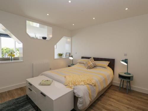 1 dormitorio con 1 cama extragrande y 2 ventanas en The Studio en Weston-super-Mare