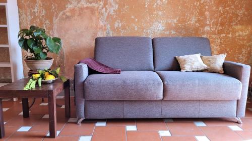ein blaues Sofa im Wohnzimmer mit einem Tisch in der Unterkunft Apartment San Frediano in Florenz